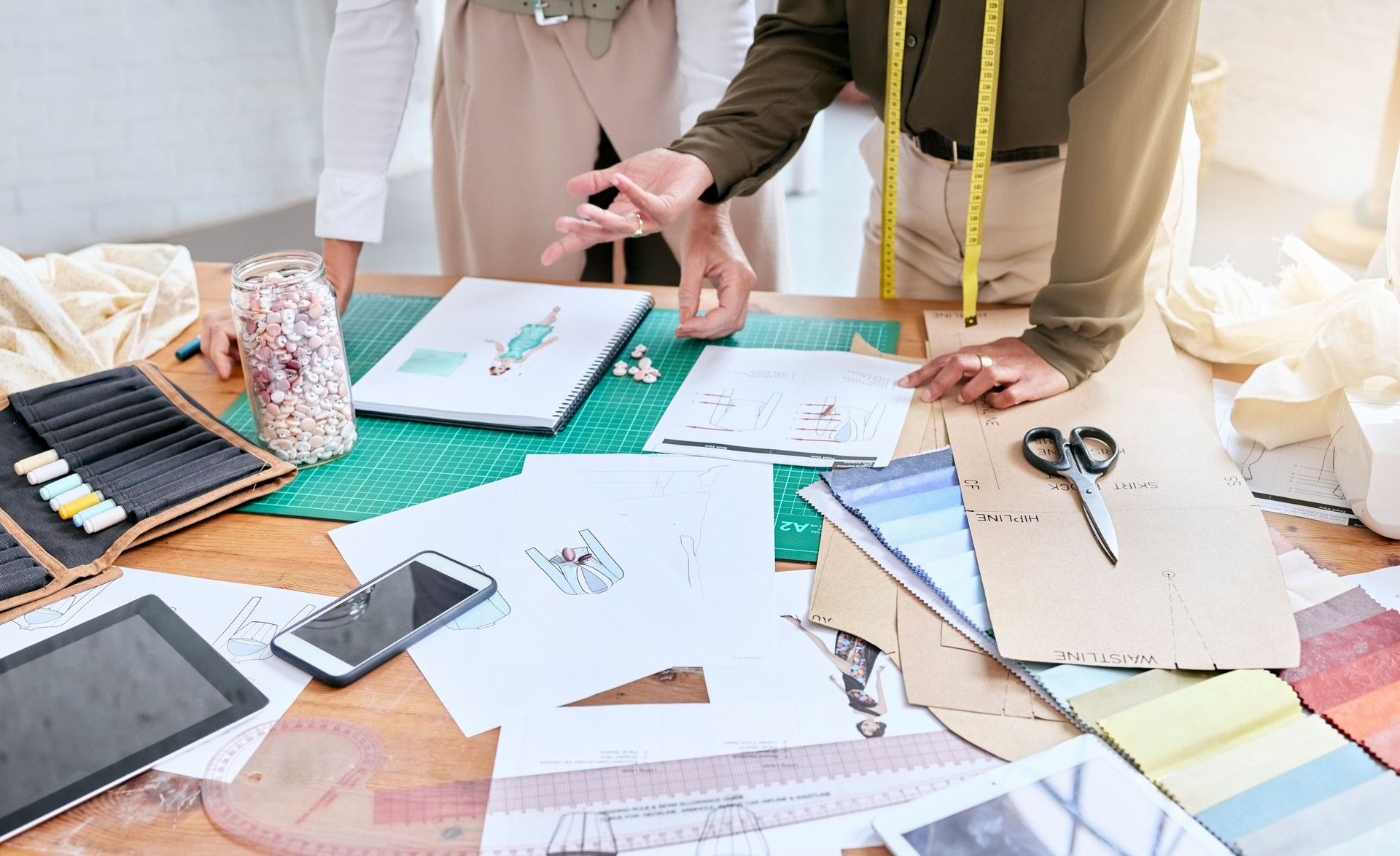 Planning, creative and fashion designer hands with teamwork, collaboration and textile workspace. Creativity, sketch and studio, workshop or manufacturing worker for ideas, art vision and project